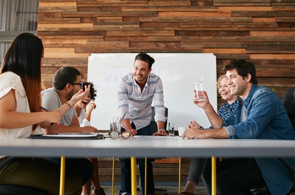 A team planning a project kick-off meeting around a table. 