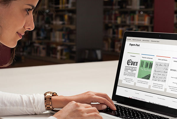 Click the photo of a researcher in a library using the Papers Past digital archive to learn how it has revolutionised research in NZ.