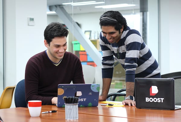 Boost software engineers discuss a project. Click to apply for a software engineer role at Boost.
