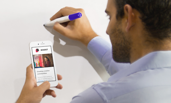 Click the photo of a man taking notes at a whiteboard from an issue of Boost News to view an archive of past issues. 